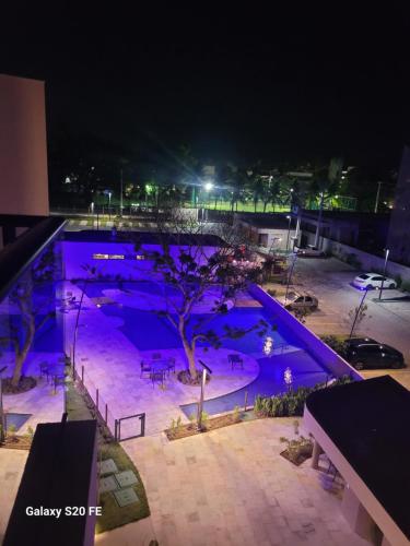 a large swimming pool at night with purple lighting at Malia Beach 302 D - Muro Alto - Porto de Galinhas in Porto De Galinhas