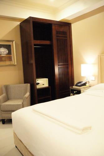 a hotel room with a bed and a chair at Hotel Morobe in Lae