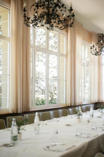 a dining room with tables and chairs and windows at Château des Comtes de Challes in Challes-les-Eaux