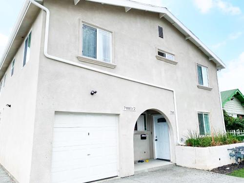 a white house with two garage doors at Blue Stay near BMO Stadium and USC Private Room in Los Angeles