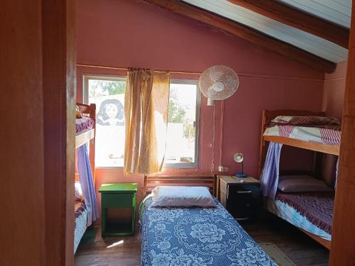 a bedroom with two bunk beds and a window at Hostel Lo de Milton in Barra de Valizas
