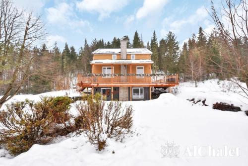 ein Haus mit einer Terrasse im Schnee in der Unterkunft Lakaban - familial & paisible in Saint-Raymond