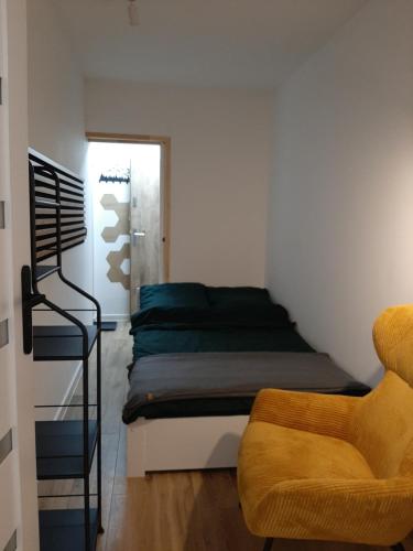 a bedroom with a bed and a chair in it at W Izerach - Apartament Superior in Szklarska Poręba