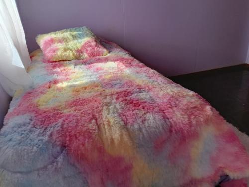 a colorful blanket on a bed in a room at Arriendo Cabaña Por Dia in La Chamiza
