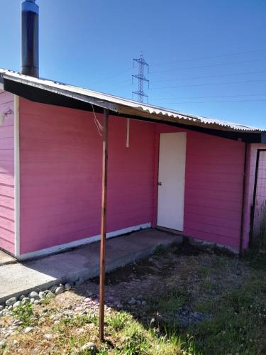 a pink house with a pole in front of it at Arriendo Cabaña Por Dia in La Chamiza