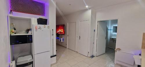 une cuisine avec un réfrigérateur blanc dans une pièce dans l'établissement Cozy apartment Villepinte, à Villepinte