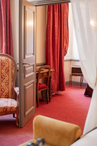 a room with red carpet and red curtains and a door at Château des Comtes de Challes in Challes-les-Eaux