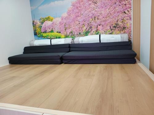 a living room with a couch and a painting at Surf99一棟貸切80平米 一松海岸とコンビニ徒歩圏 200平米芝庭 BBQ 専用焚き火台 in Chosei