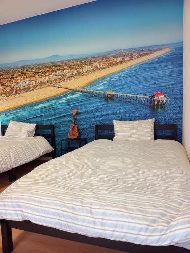 a bedroom with two beds and a view of a beach at Surf99一棟貸切80平米 一松海岸とコンビニ徒歩圏 200平米芝庭 BBQ 専用焚き火台 in Chosei