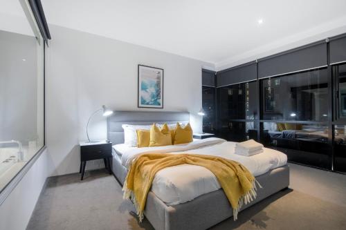 a bedroom with a large bed with yellow pillows at Circle on Cavill - Self Contained & Privately Managed - Wow Stay in Gold Coast