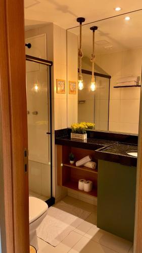 a bathroom with a toilet and a shower and a sink at Malia Muro Alto - Porto de Galinhas - Flat para 5 pessoas vista piscinas in Ipojuca