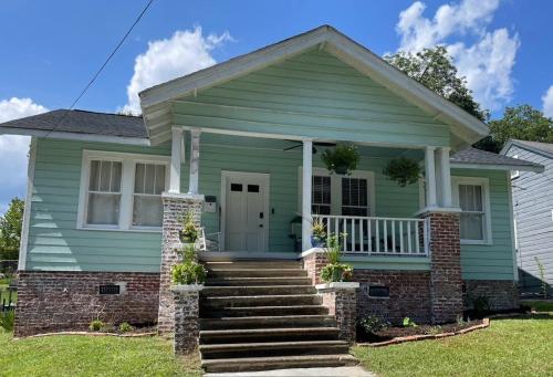 ein grünes Haus mit einer Veranda und einer Treppe in der Unterkunft Sparkle City Cottage in Spartanburg