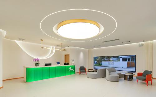 a hospital lobby with a green counter and chairs at Yangshuo Pony Hotel - Yulong River in Yangshuo