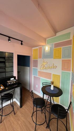 a room with a table and chairs and a piano at Apê Coloridinho - Centro in Serra Negra