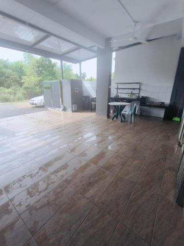 a large empty room with a wooden floor and tables at Serena Villa Mslim Only With Indoor Private Pool in Port Dickson