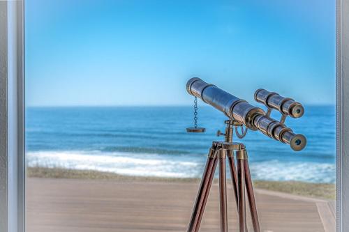 a telescope on a tripod in front of the beach at Inlet Cottage in Lincoln City