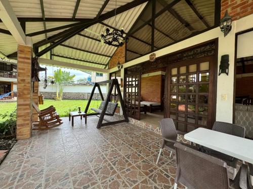 an outdoor patio with a swing and a porch at Hotel Boutique Villas de San Sebastián in Villavicencio