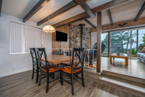 a dining room with a wooden table and chairs at Woodley Beach House in Lincoln Beach