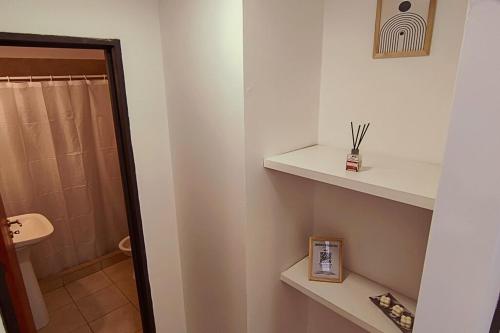 ein Badezimmer mit weißen Regalen und einer Dusche in der Unterkunft Departamento Moderno - Punto Alto in Villa María