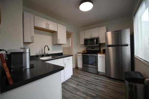 a kitchen with white cabinets and a stainless steel refrigerator at Edgewater Stay on W78th in Cleveland