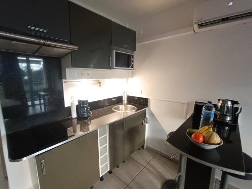 Una cocina con un bol de fruta en la encimera. en Studio vue Mer Gosier, Guadeloupe, en Le Gosier
