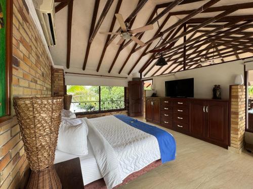 a bedroom with a large bed and a television at Hotel Boutique Villas de San Sebastián in Villavicencio