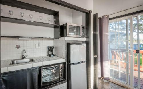 a kitchen with a sink and a refrigerator at Taft Cottage in Lincoln City
