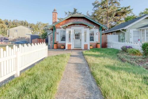 a white fence in front of a house at Taft Cottage in Lincoln City
