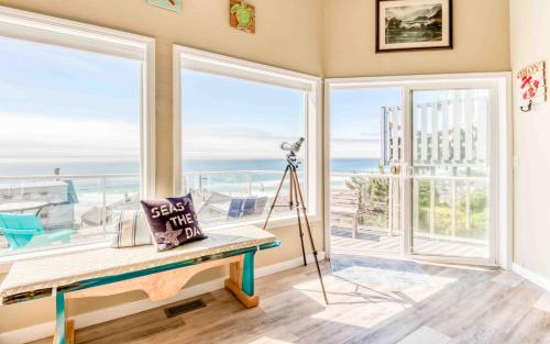 a room with large windows and a table with a pillow at Seas the Day in Lincoln City