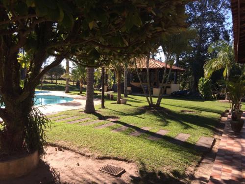 a yard with a pool and trees and a house at Pousada Sarapui in Sarapuí