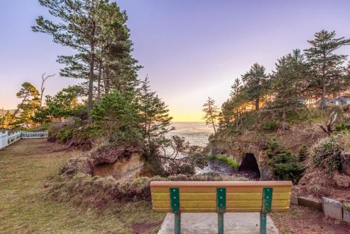 a bench sitting on a path near the ocean at Rememberance in Depoe Bay
