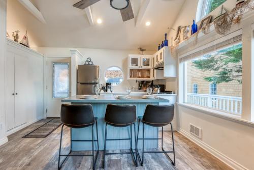 a kitchen with a blue island with stools at Rememberance in Depoe Bay