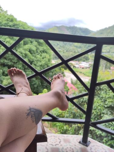 a person with a tattoo on their leg sitting on a balcony at La Casa Morada in San Ramón