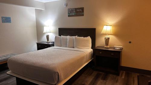 a hotel room with a bed and two night stands with lamps at Inn at the Sea in Long Beach