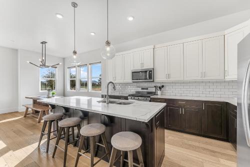 a kitchen with white cabinets and a large island with bar stools at Villa #07 at Bloomington Country Club condo in St. George
