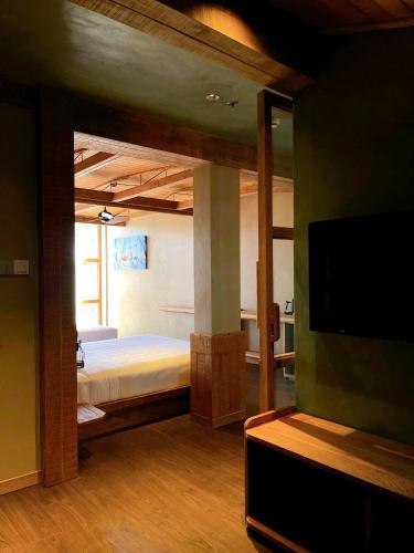 a bedroom with a bed and a flat screen tv at The Pink Boutique Hotel in Da Lat