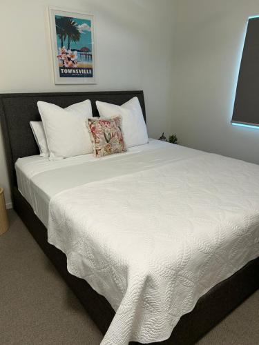 a large bed with white sheets and pillows at Walk to Palmer B&B - U21 in Townsville