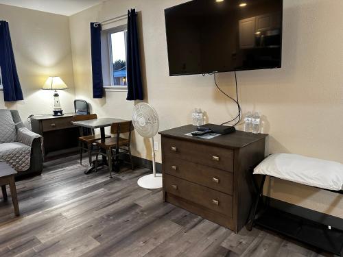 a hotel room with a bed and a television on the wall at Inn at the Sea in Long Beach