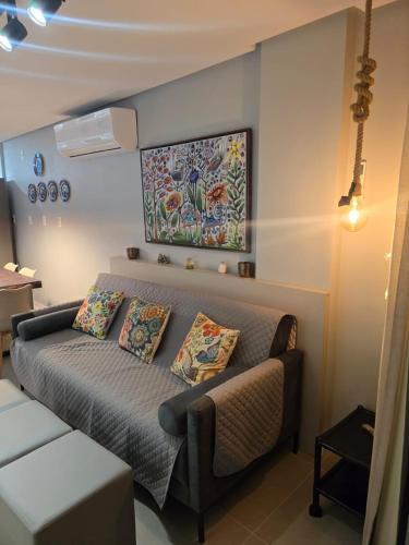 a room with a bed with pillows and a painting on the wall at Charme e requinte em Carneiros com 2 quartos in Tamandaré