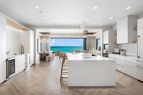 a kitchen with white cabinets and a view of the ocean at Villa Julia and Villa Angelina in Leeward