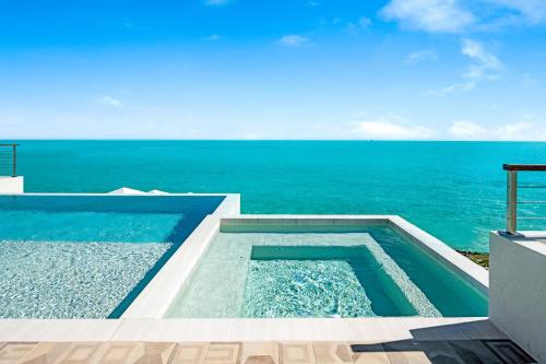 a swimming pool with the ocean in the background at Villa Julia and Villa Angelina in Leeward