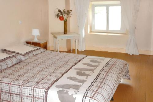 a bedroom with a bed and a window and a table at Maison charmante à Ranrupt avec jardin et terrasse in Grandrupt