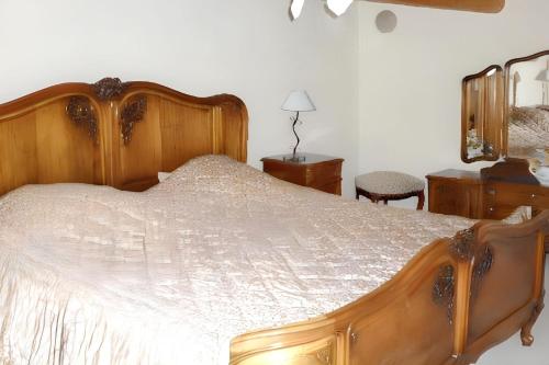 a bedroom with a large bed with a wooden frame at Maison charmante à Ranrupt avec jardin et terrasse in Grandrupt
