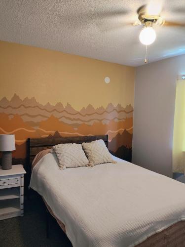a bedroom with a bed with a painting on the wall at Cozy town house in Wall! in Wall