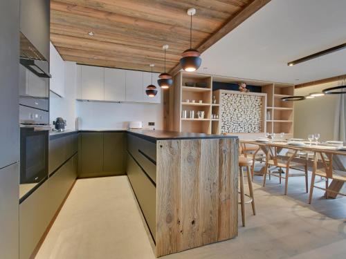 une cuisine ouverte avec un îlot en bois et une salle à manger dans l'établissement Duplex de Prestige 6 Chambres, Route du Belvédère, Skis aux Pieds, Jacuzzi & Parking Privé - FR-1-613-8, à Méribel