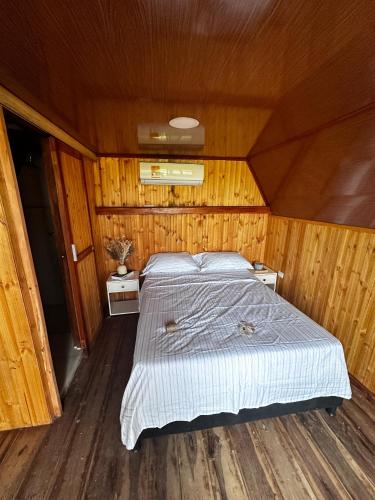 a bed in the middle of a room with wooden walls at Playa Aescondidas in Ríohacha