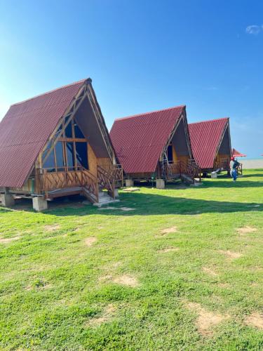 a row of houses with red roofs in a field at Playa Aescondidas in Ríohacha
