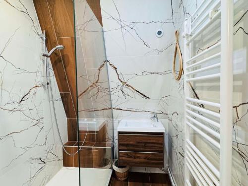 La salle de bains est pourvue d'un lavabo et de murs en marbre. dans l'établissement Les 2 Alpes - Appartement cosy 6 pers, au cœur de la station - FR-1-546-59, à Les Deux Alpes