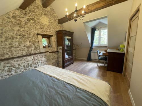 une chambre avec un lit et un mur en pierre dans l'établissement Gîte de charme aux portes d'Amboise avec grand jardin et Wi-Fi - FR-1-381-604, à Reugny