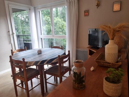 une salle à manger avec une table, des chaises et une télévision dans l'établissement Spacieux T3 à Seignosse au bord de l'océan avec balcon - FR-1-239-1095, à Seignosse